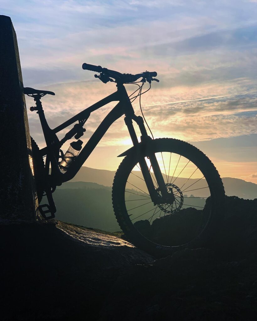 Silhouette of mountain bike and trig point, Braid Hills, Edinburgh.